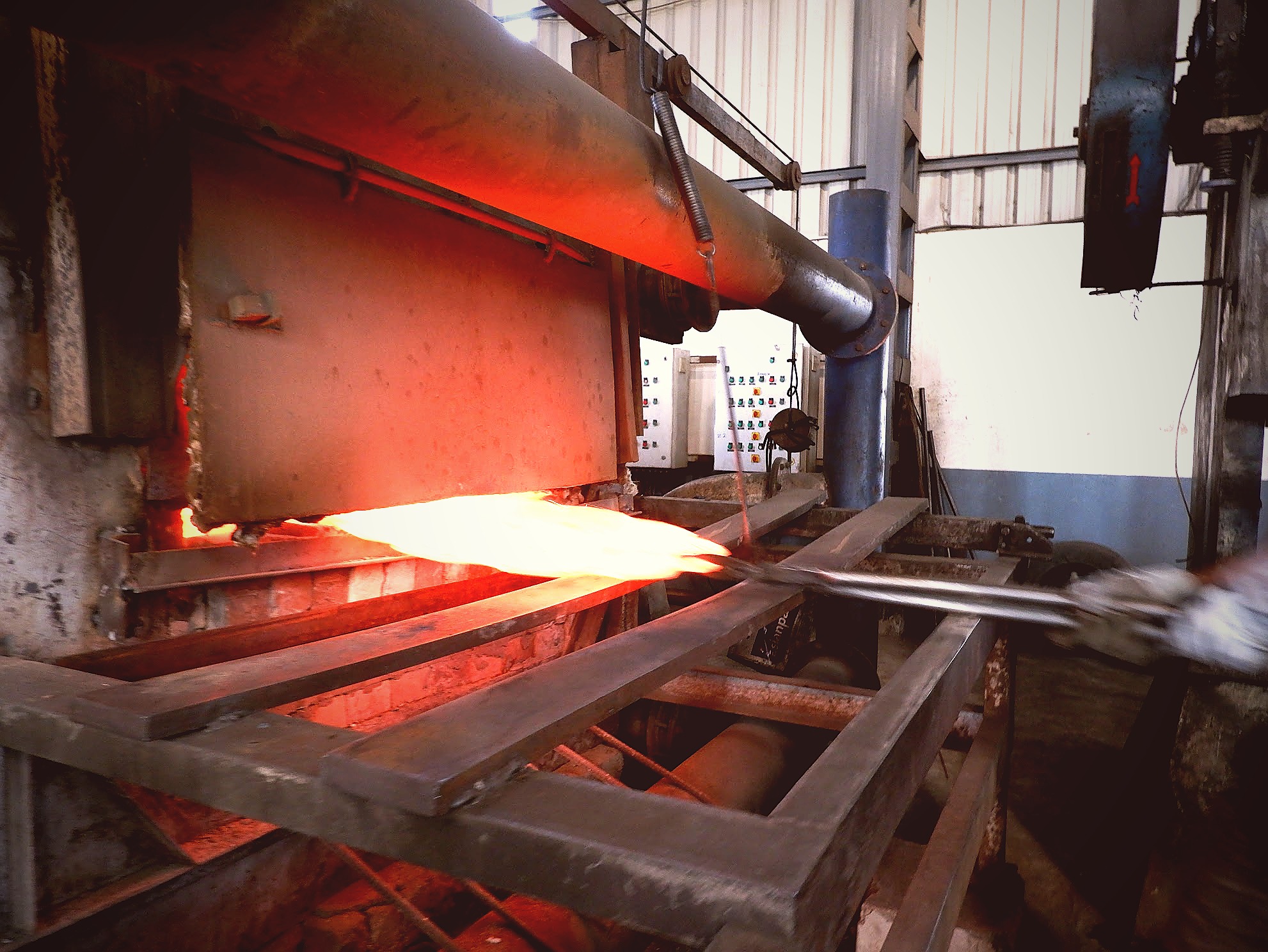 Disc blade exiting 8-zone conveyor furnace at austenitisation temperature